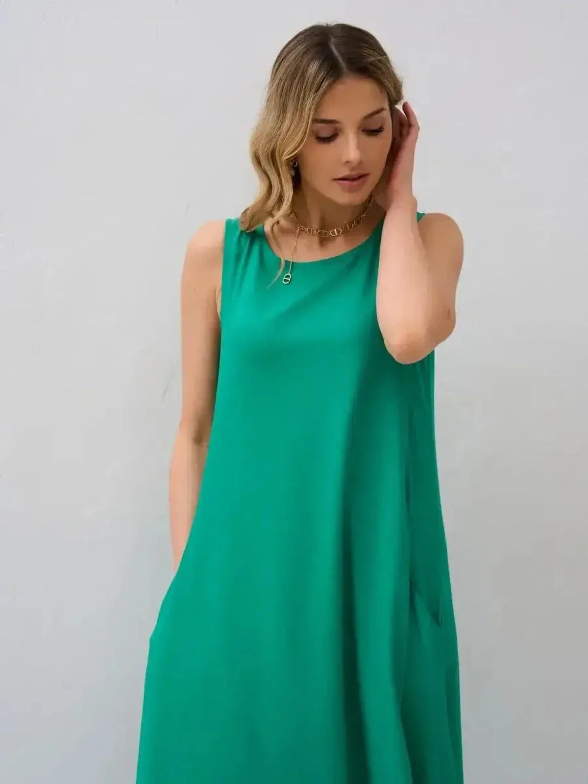 Model wearing a flowy green maxi dress with pockets, showcasing effortless summer elegance and comfort.