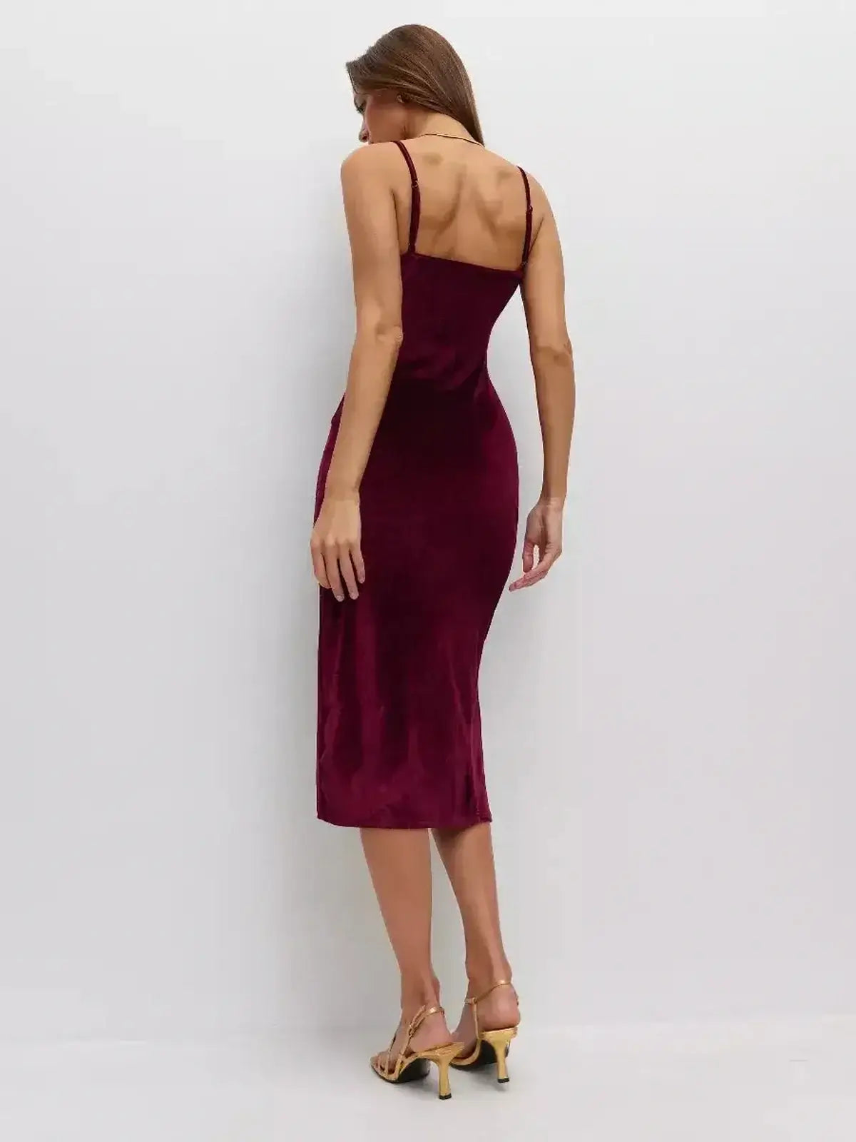 Back view of a woman in a Midi Dress Velvet Crush by Lauven, showcasing the luxurious velvet texture and form-fitting design.