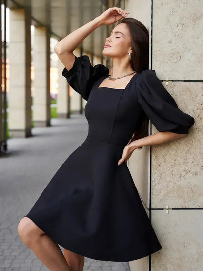 Lauven Midnight Grace Black Mini Dress with puff sleeves and square neck, showcasing elegance and comfort in a timeless silhouette.