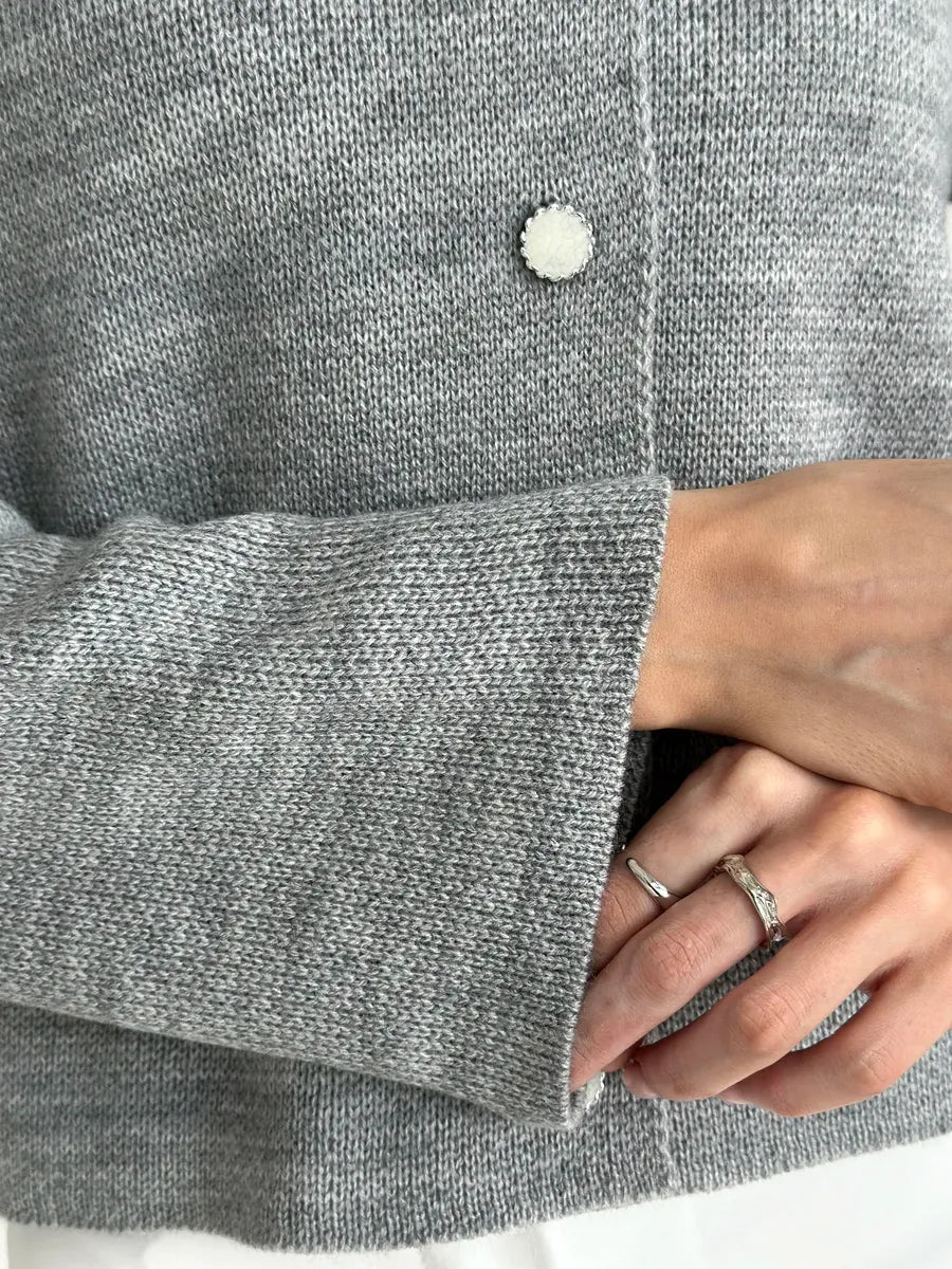 Detail of the Mist Cardigan by Lauven, showcasing cozy gray knit texture and button closure.