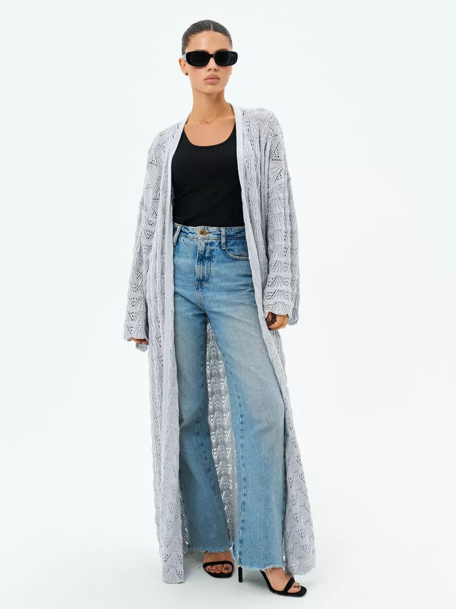 Model wearing the Mist Cardigan by Lauven, a lightweight openwork summer cardigan in light gray.