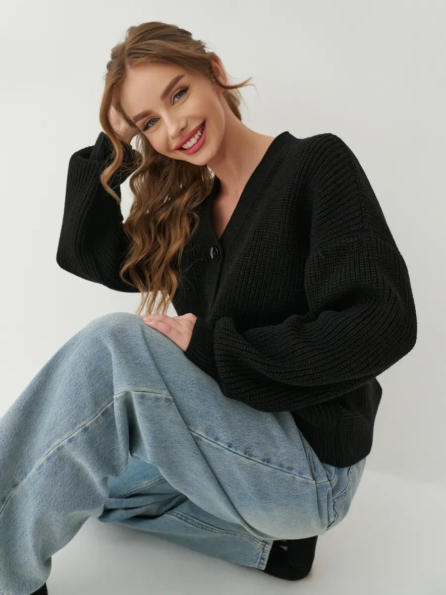 Onyx Cardigan by Lauven, stylish oversized black knit cardigan worn by a smiling woman.
