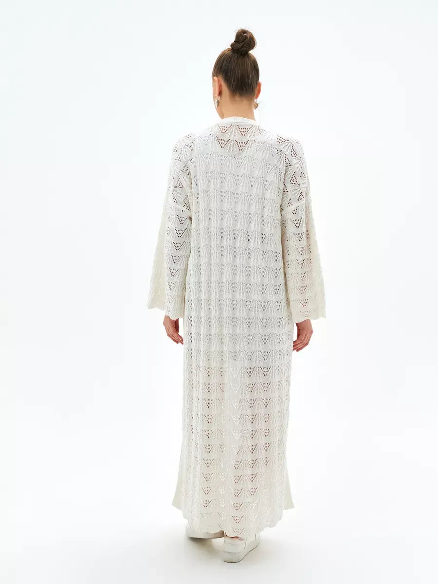 Back view of a woman wearing the Pearl Cardigan from Lauven, showcasing its intricate openwork design and lightweight fabric.