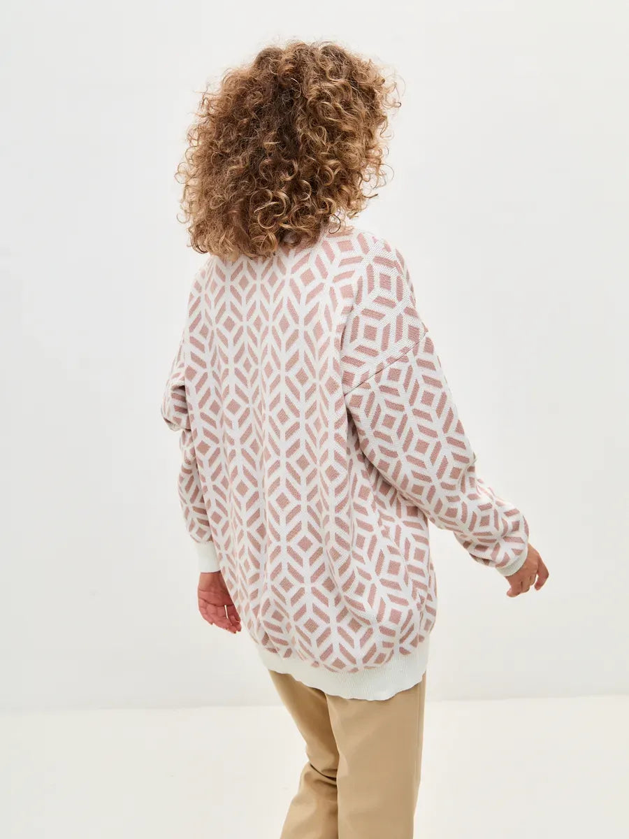 Back view of a woman wearing a Powder Cardigan in Milk and Powder Pink by Lauven, showcasing a stylish longline design.
