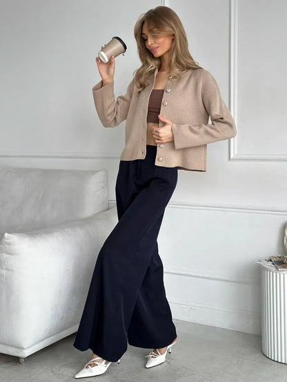 Elegant woman wearing Sable Cardigan from Lauven, styled with wide-leg pants, holding a coffee cup.