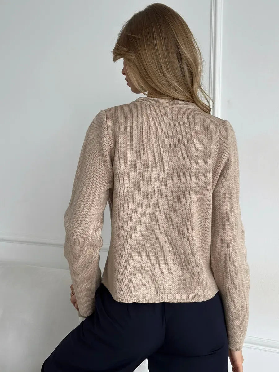 Back view of a woman wearing the Sable Cardigan by Lauven, showcasing its elegant beige cropped design.