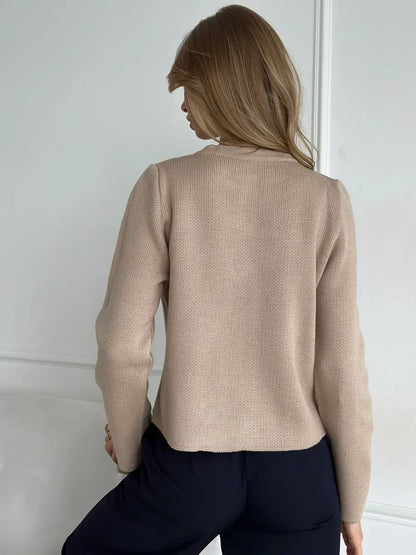 Back view of a woman wearing the Sable Cardigan by Lauven, showcasing its elegant beige cropped design.