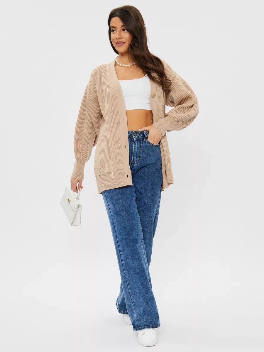 Woman wearing a relaxed Sandstone Cardigan by Lauven, styled with blue jeans and a white top.