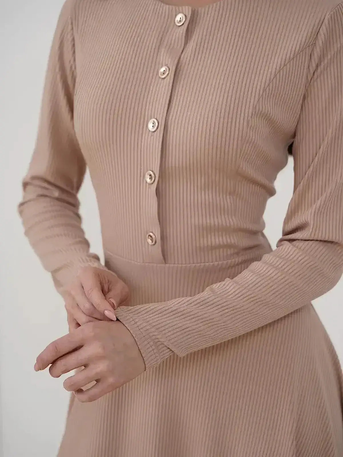 Close-up of Sculpted Ease Midi Dress by Lauven, showcasing ribbed knit fabric and gold-tone button details.