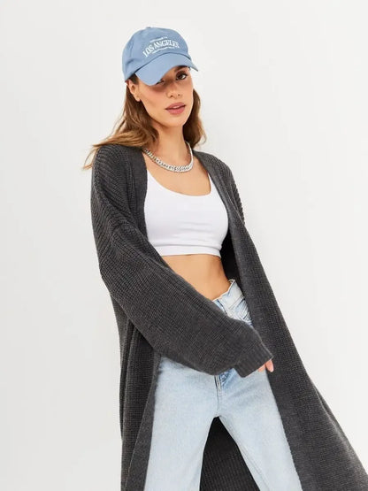 Model wearing the Shadow Cardigan by Lauven, styled with a cap and jeans for a trendy look.