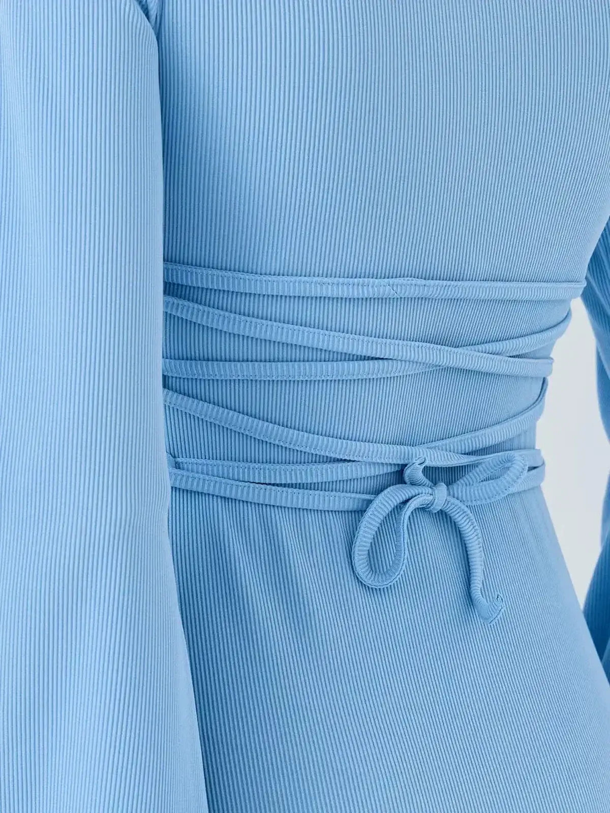 Sky Belle by Lauven, showcasing the back detail of a pastel blue ribbed knit mini dress.