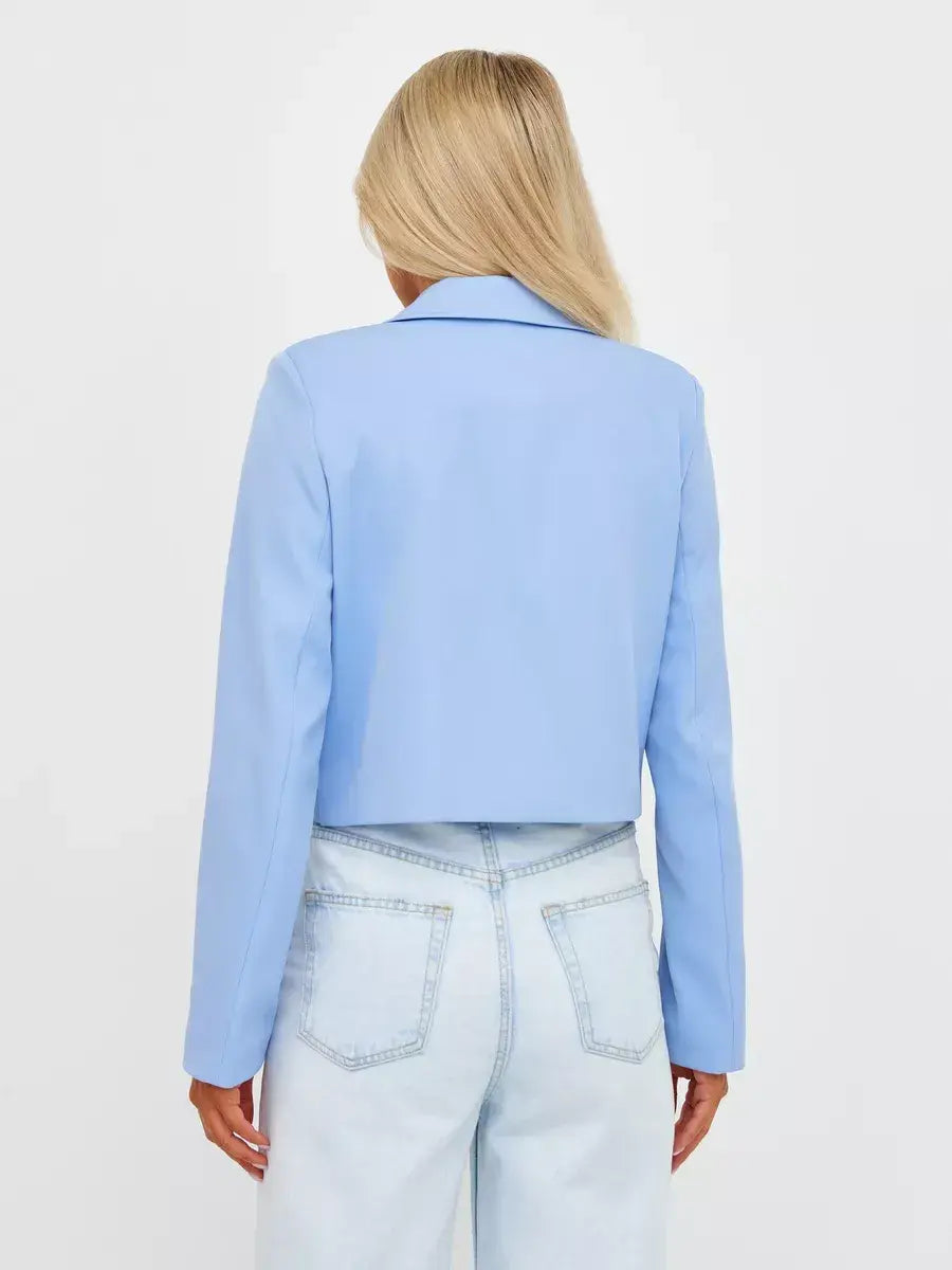 Back view of a woman wearing the Skyline Blazer by Lauven in soft blue, featuring a cropped tailored design.