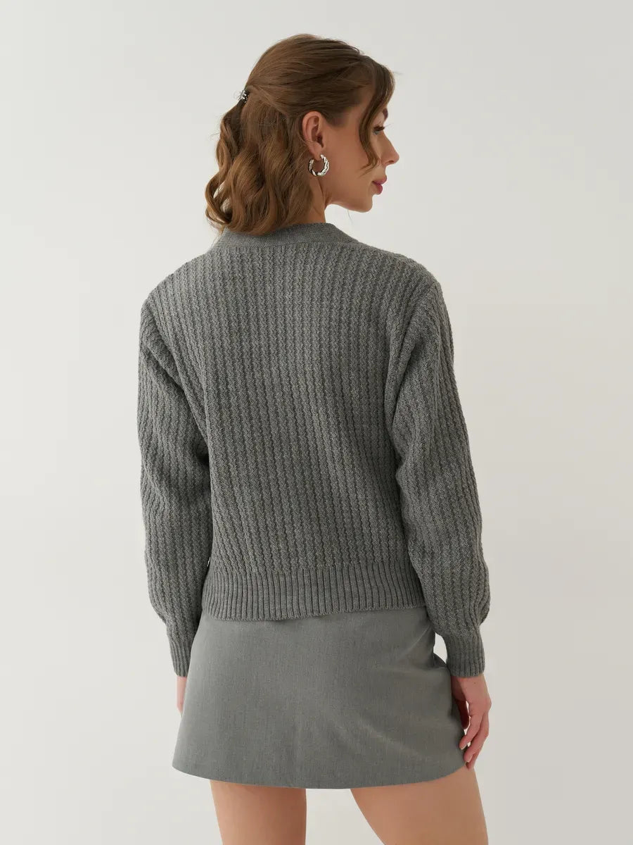 Back view of a model wearing the Lauven Slate Cardigan in gray, showcasing its oversized cropped design.