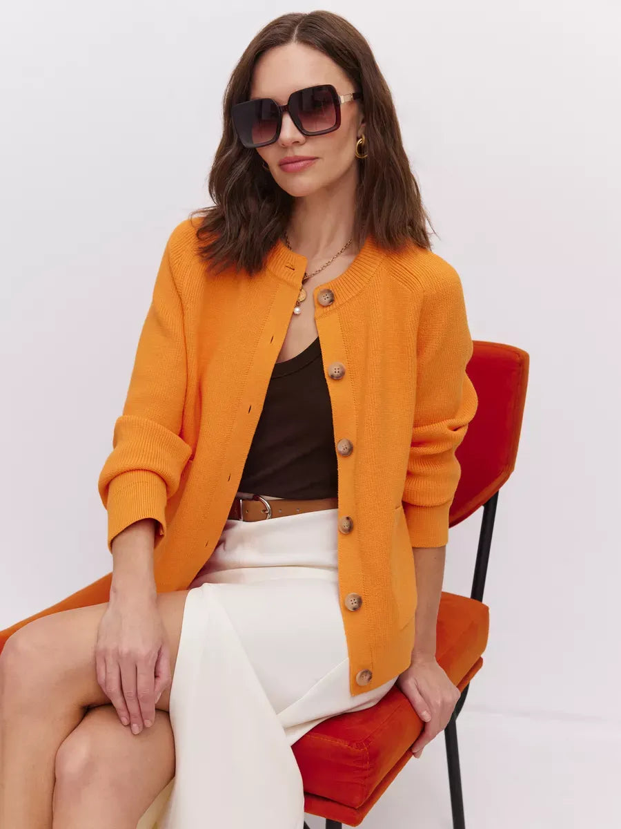 Solana Cardigan by Lauven, vibrant button-up knit in bold orange, showcased with modern elegance on a model.
