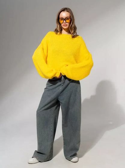 Model wearing the bold Solara Sweater by Lauven in bright yellow, paired with oversized denim for a trendy look.