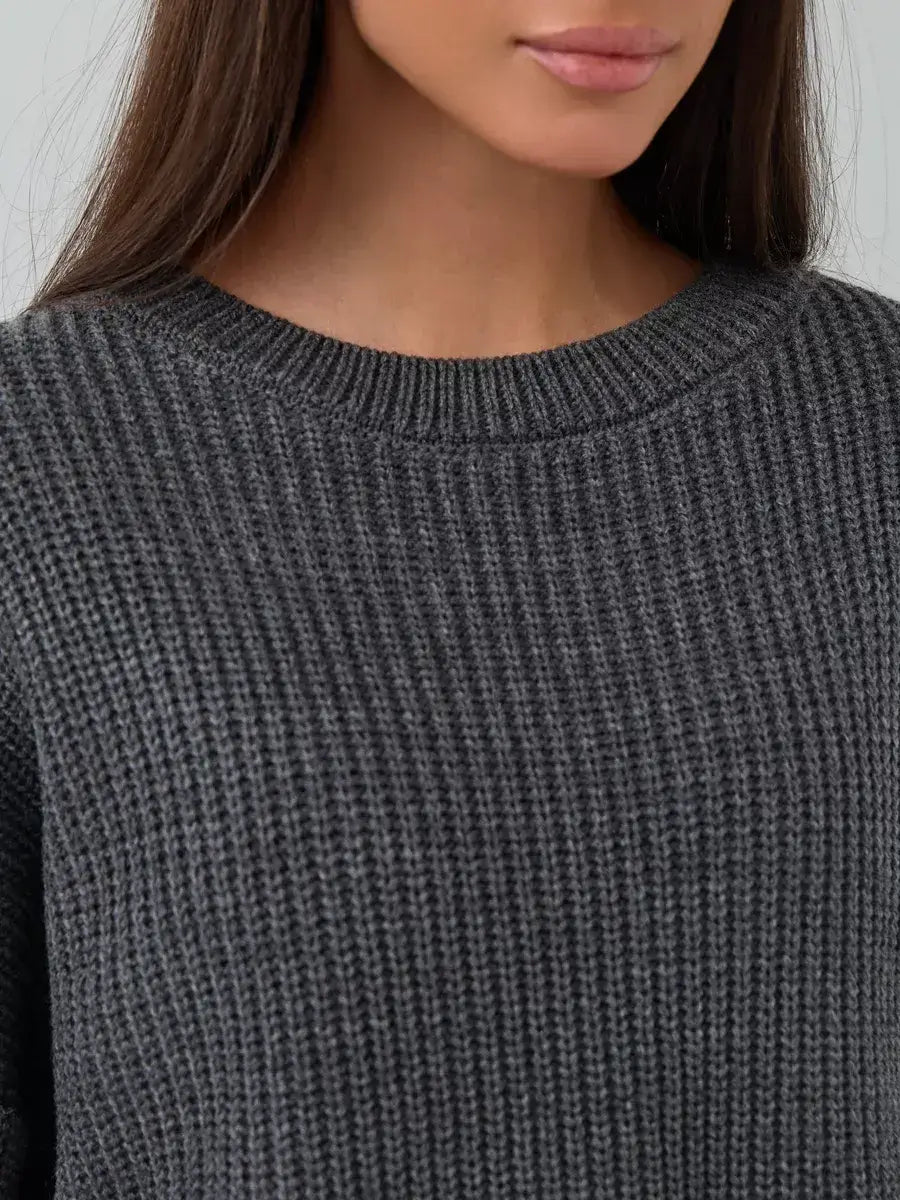 Close-up of model wearing Lauven Vera Sweater, an oversized dark gray knit with a crew neck design.