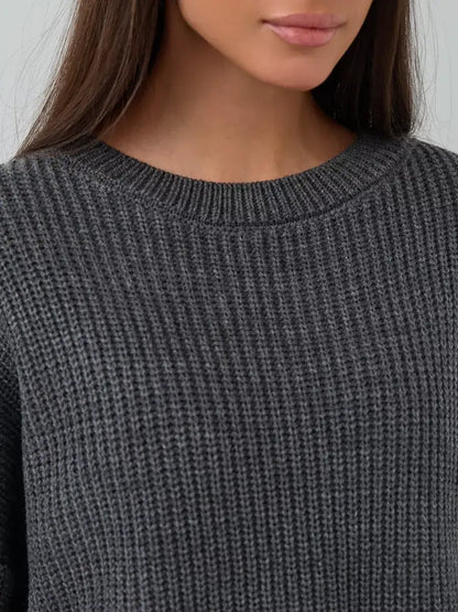 Close-up of model wearing Lauven Vera Sweater, an oversized dark gray knit with a crew neck design.