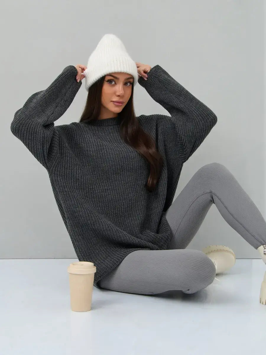 Vera Sweater by Lauven in oversized dark gray knit with crew neck, styled with a white beanie and gray leggings.