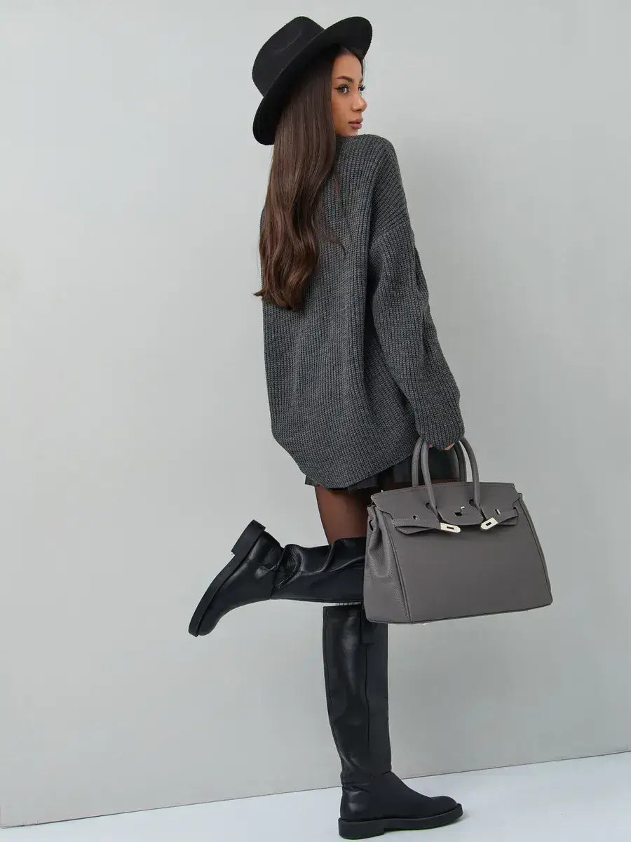 Woman wearing a dark gray oversized knit Vera Sweater with a hat and handbag, featuring a chic and modern style.
