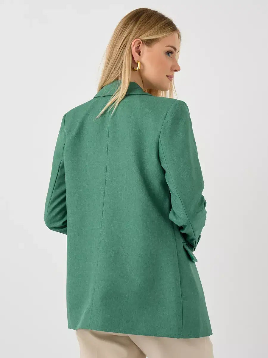 Woman wearing a green oversized blazer from Lauven, showcasing the back view of the Verde Blazer.