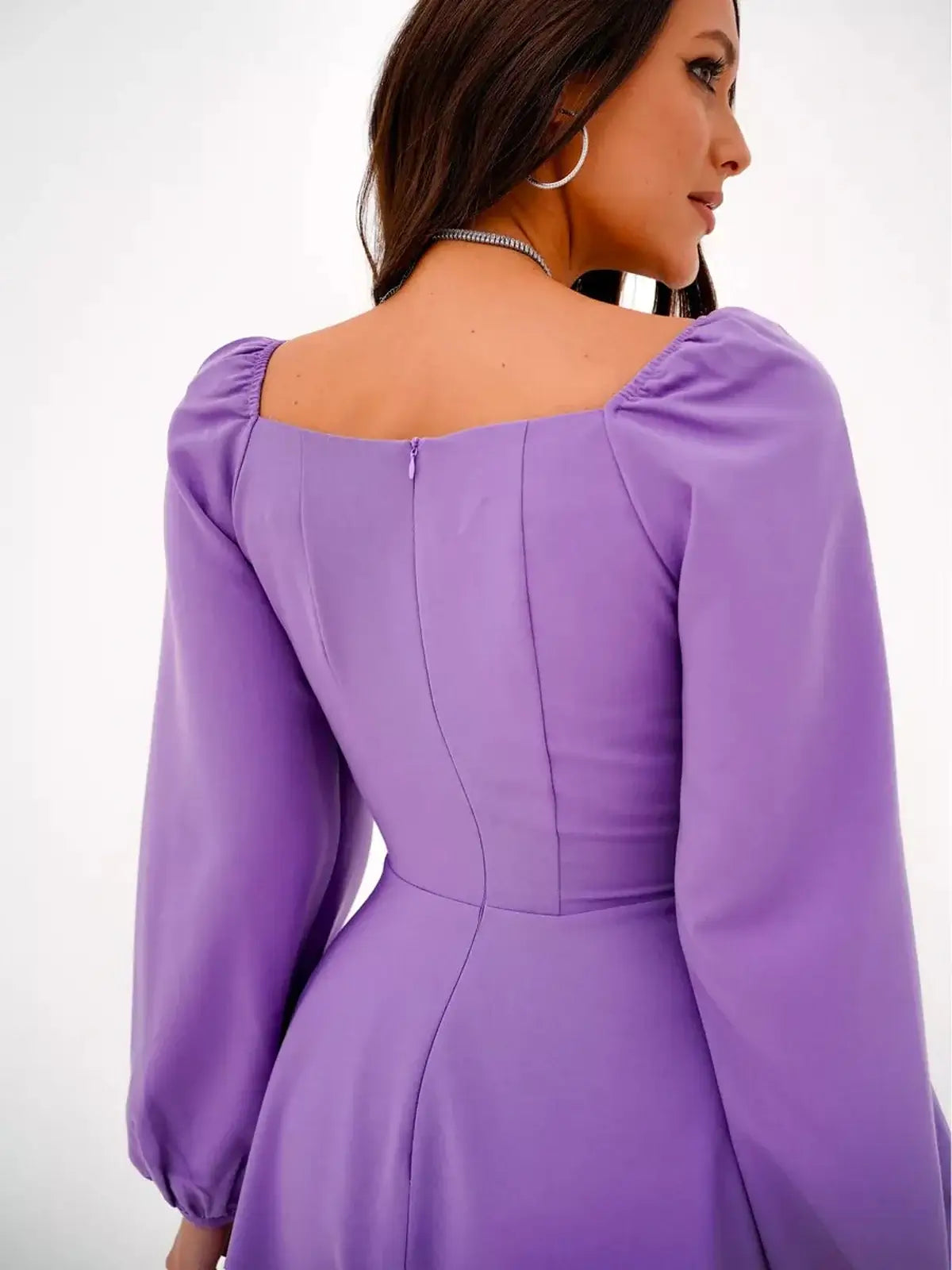 Back view of Lavender Grace mini dress with a square neckline and puff sleeves in soft purple fabric.