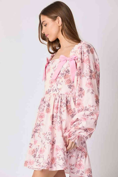 Lila Mini Dress in pink floral print with bow accents, perfect for summer occasions, weddings, and cocktail events.