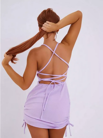 Back view of a model wearing the Lilac Crush mini dress by Lauven, featuring adjustable criss-cross straps.