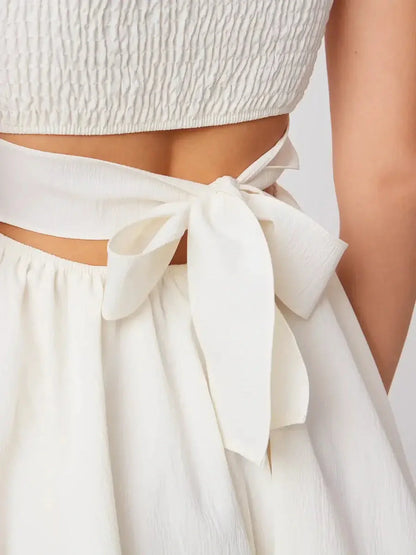 Close-up of the elegant back bow detail on the Luna Mini Dress in crisp white, showcasing its stylish design.