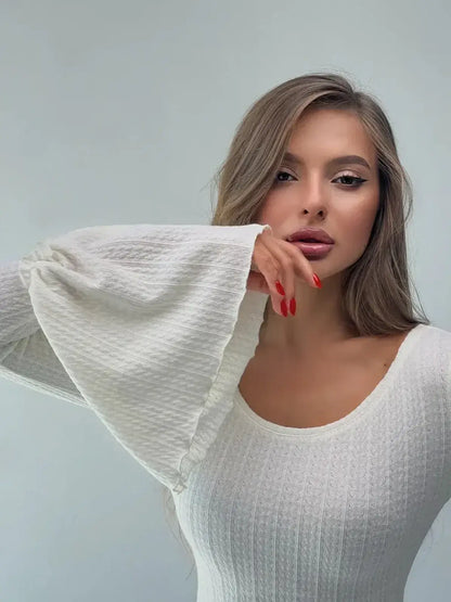 Model showcasing the Lustre Maxi Dress featuring dramatic bell sleeves and a sculpted knit silhouette.