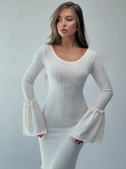 Model wearing a white Lustre Maxi Dress with bell sleeves, showcasing its elegant sculpted silhouette and flounced hem.