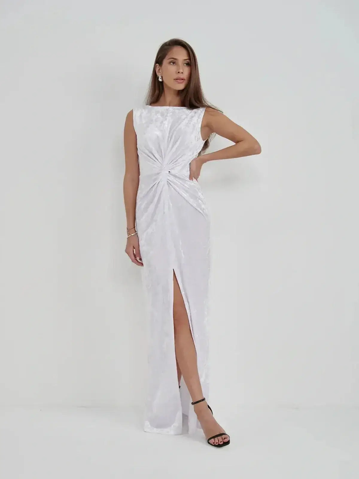 Elegant model in Lustre Twist Maxi Dress, showcasing draped white velvet, twist detail, and an alluring slit.