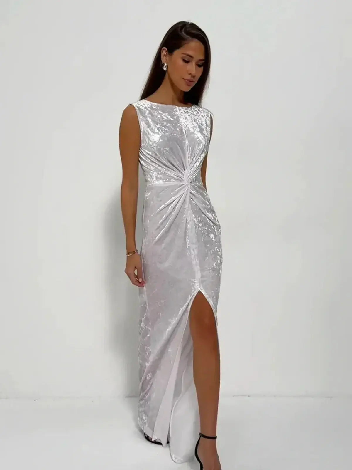Elegant model in Lustre Twist Maxi Dress featuring draped white velvet and a stylish slit, perfect for evening occasions.