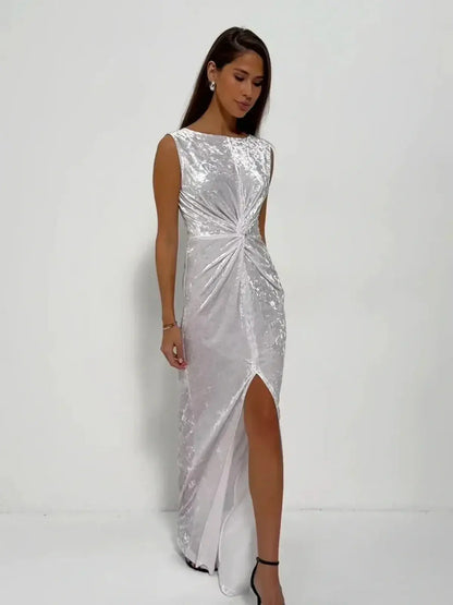 Elegant model in Lustre Twist Maxi Dress featuring draped white velvet and a stylish slit, perfect for evening occasions.