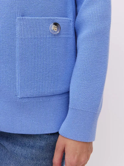 Close-up of the Lyra Cardigan by Lauven, featuring a soft blue knit texture and a button-up pocket for added elegance.