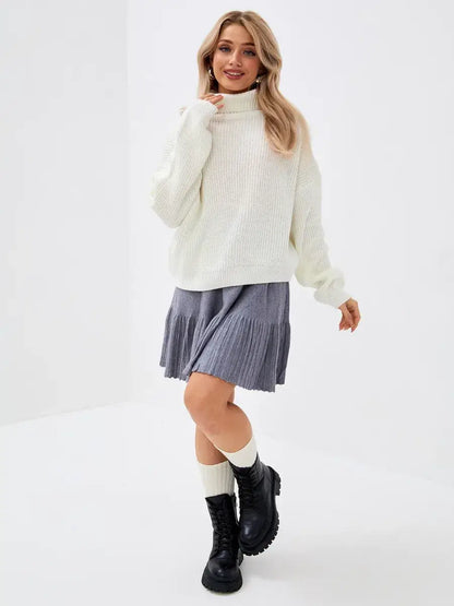 Model wearing the Lyra Sweater by Lauven, showcasing an oversized knit design with high neck in ivory.