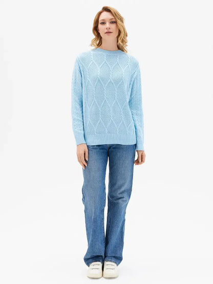 Model wearing the Lyra Sweater by Lauven in light blue cable knit design, styled with denim jeans.