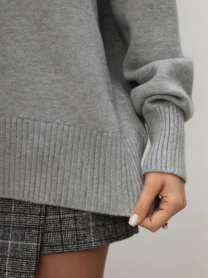 Woman wearing the Lyra Sweater, a light grey turtleneck knitwear essential by Lauven.