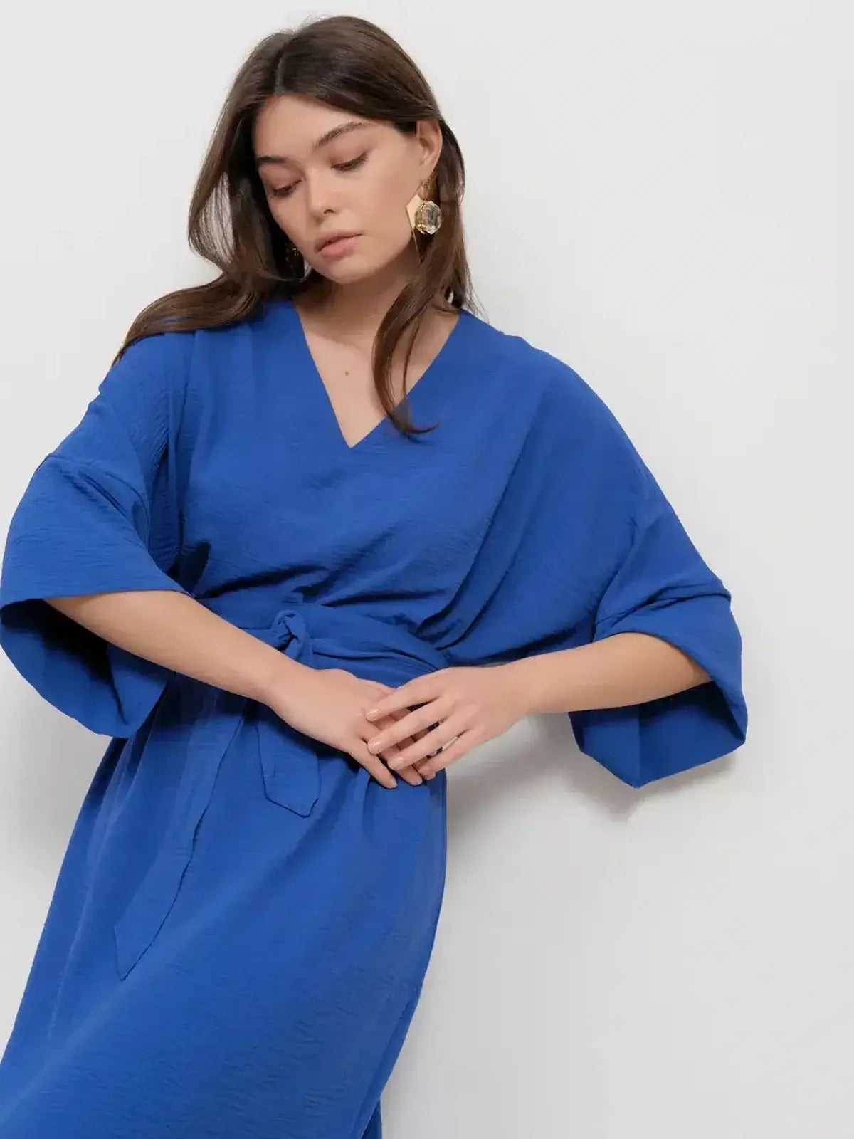 Model showcasing the Maxi Dress Azure Flow in vibrant blue, featuring a V-neckline and relaxed silhouette.