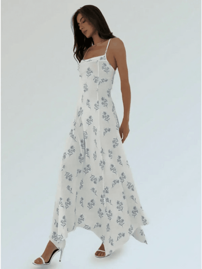 Maxi Dress Bluebelle in white with blue floral print, featuring a handkerchief hem and strappy open-back silhouette.