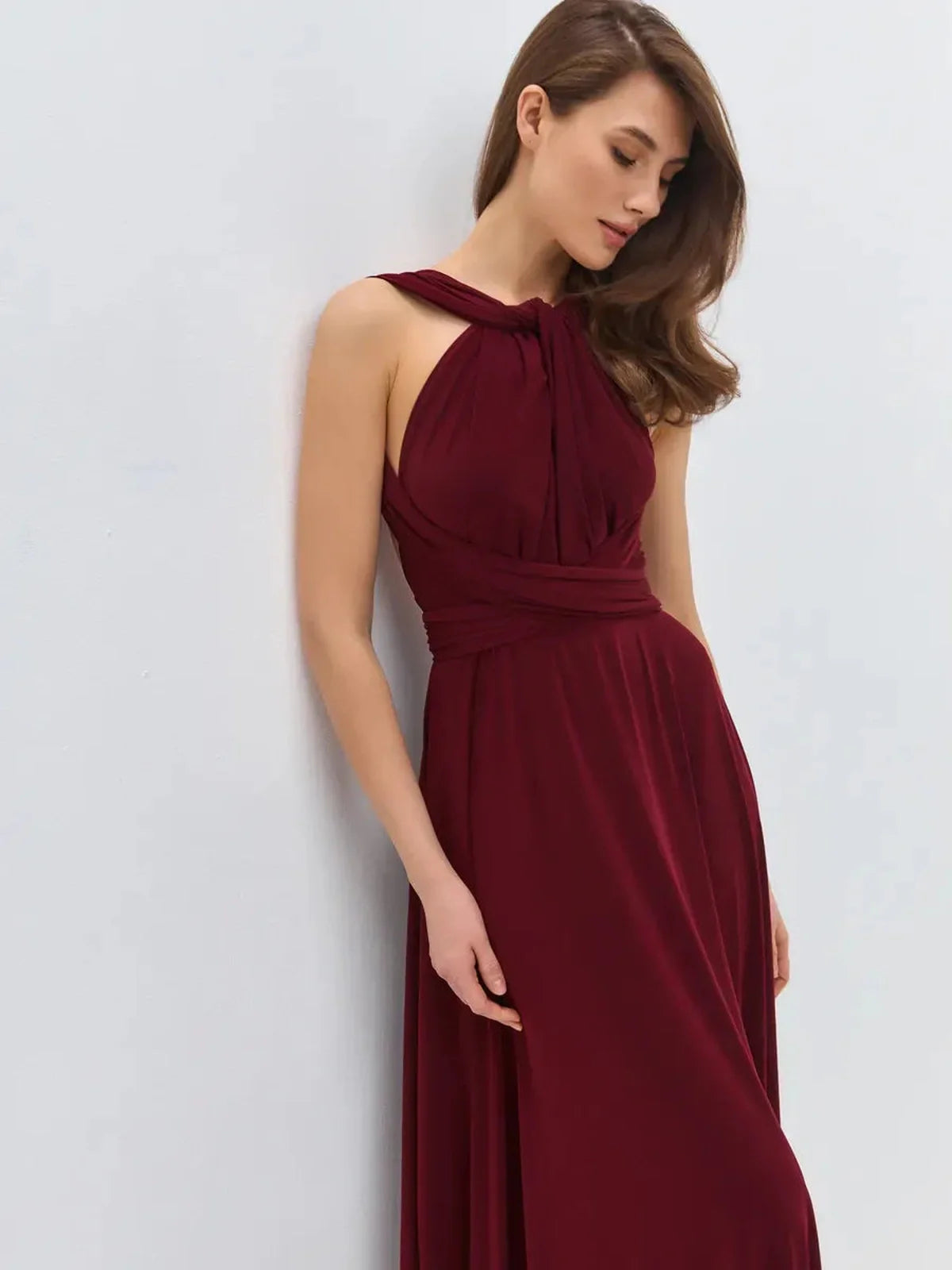 Model showcasing the Bordeaux Muse Maxi Dress in deep wine hue, featuring a convertible silhouette and elegant draping.