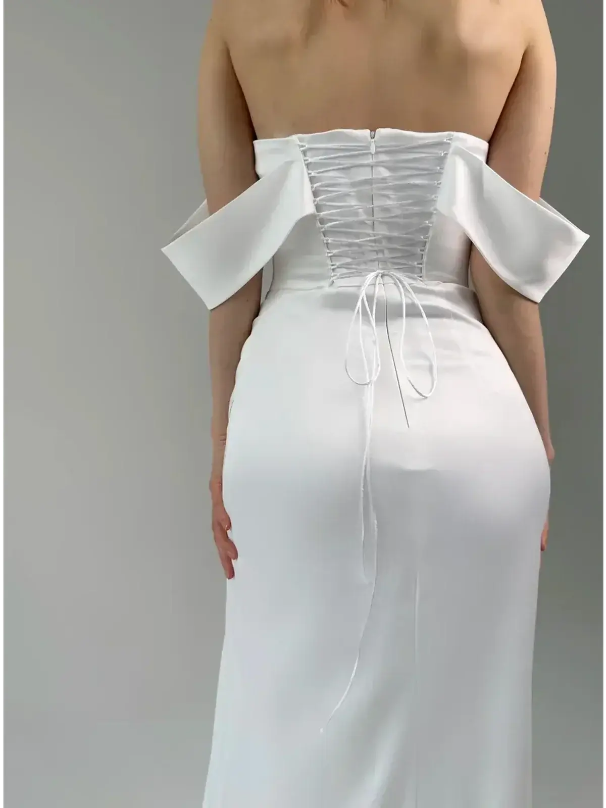 Back view of Maxi Dress Éclat showcasing off-shoulder design and corset lacing in elegant satin fabric.