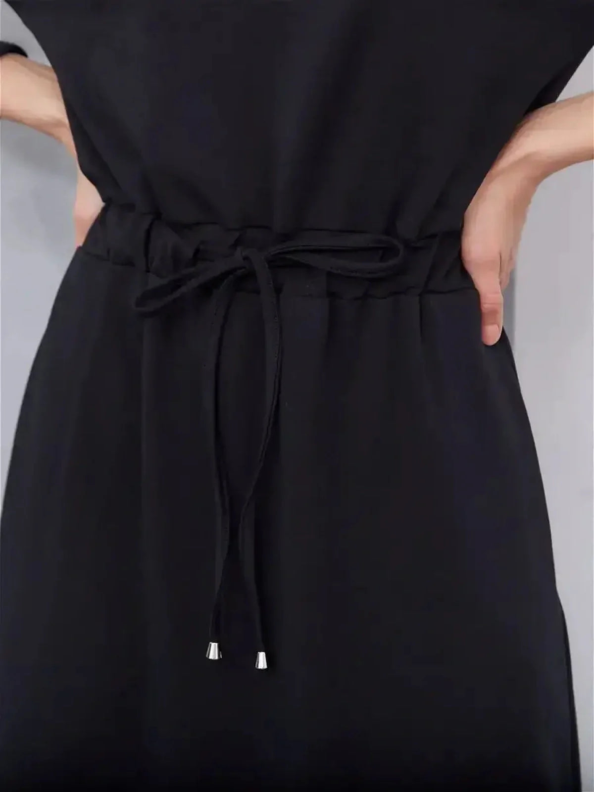 Close-up of the cinched waist detail on the black Maxi Dress Eclipse, showcasing urban elegance and comfort.