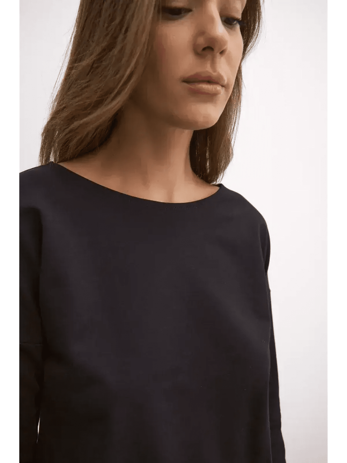 Close-up of a woman wearing the black Maxi Dress Eclipse, showcasing its sleek and elegant boat neckline.