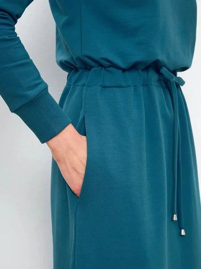Close-up of the Maxi Dress Evergreen Ease showcasing the cinched waist and pocket detail in rich forest green.