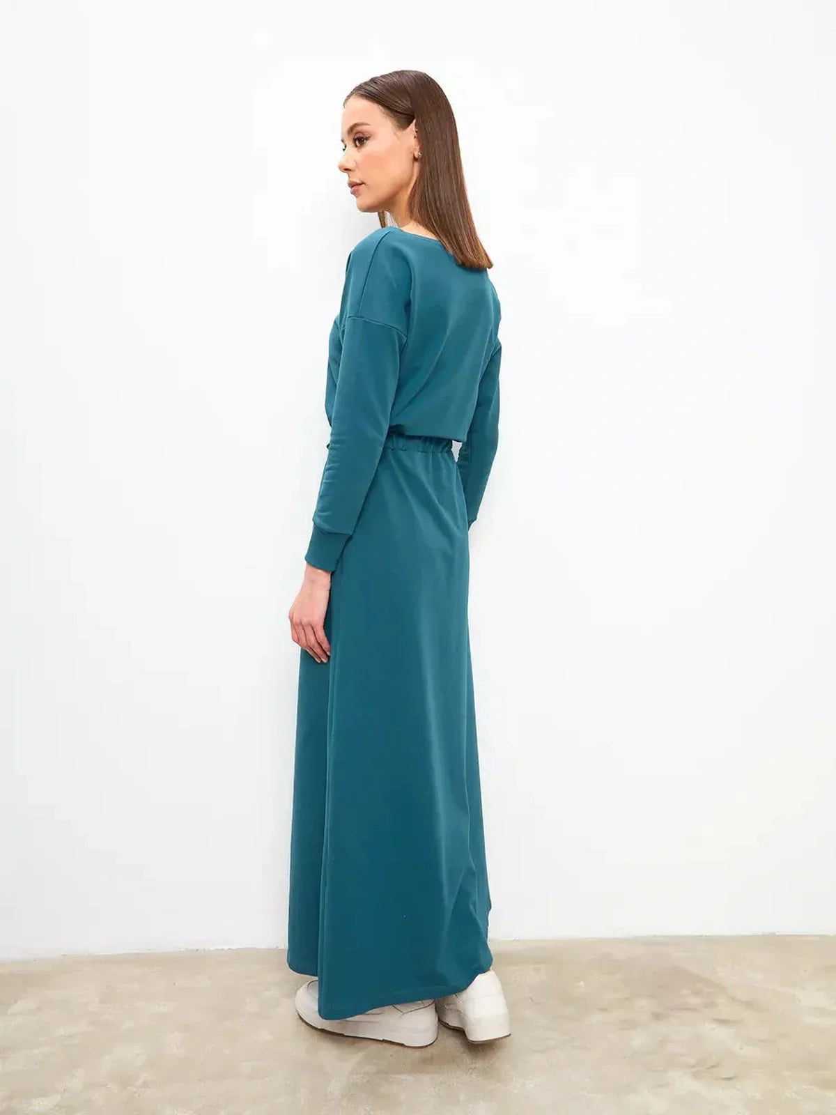 Model showcasing the Maxi Dress Evergreen Ease in forest green, featuring a cinched waist and modern silhouette.