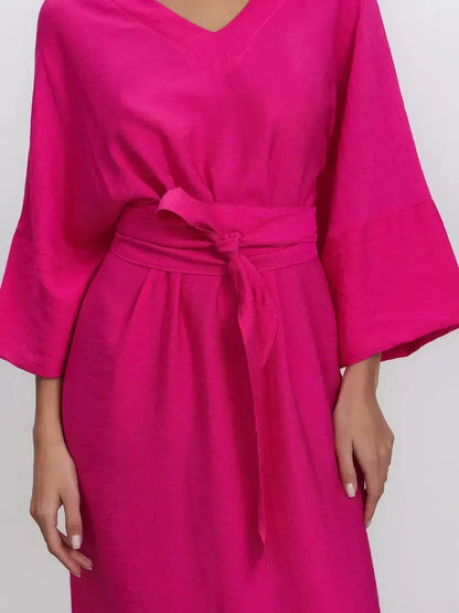 Fuchsia maxi dress with kimono sleeves and removable belt, showcasing modern femininity and effortless elegance.
