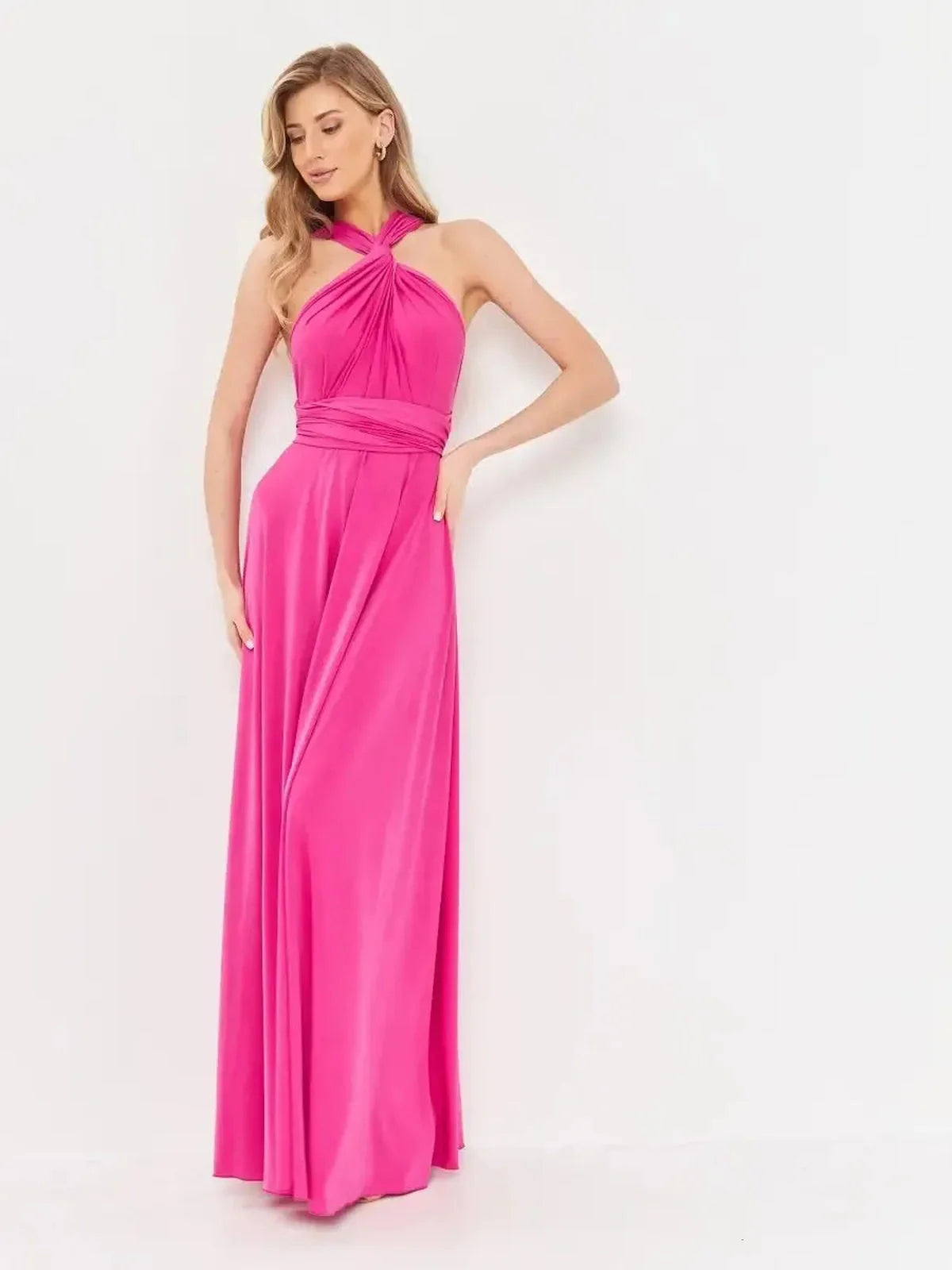 Elegant woman wearing a vibrant fuchsia pink maxi dress with halter neckline and draped convertible style.