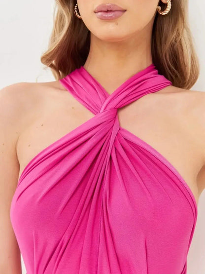 Close-up of a woman's neckline in a fuchsia pink maxi dress with a twisted halter design.