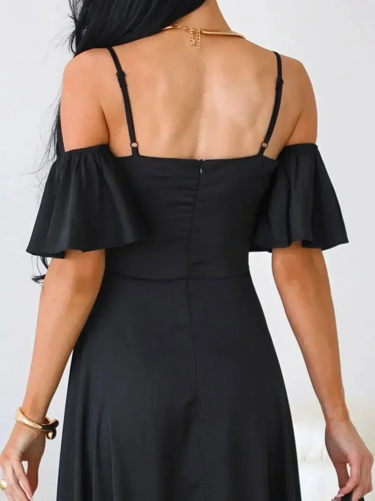 Back view of elegant black maxi dress with off-shoulder flutter sleeves and adjustable straps.