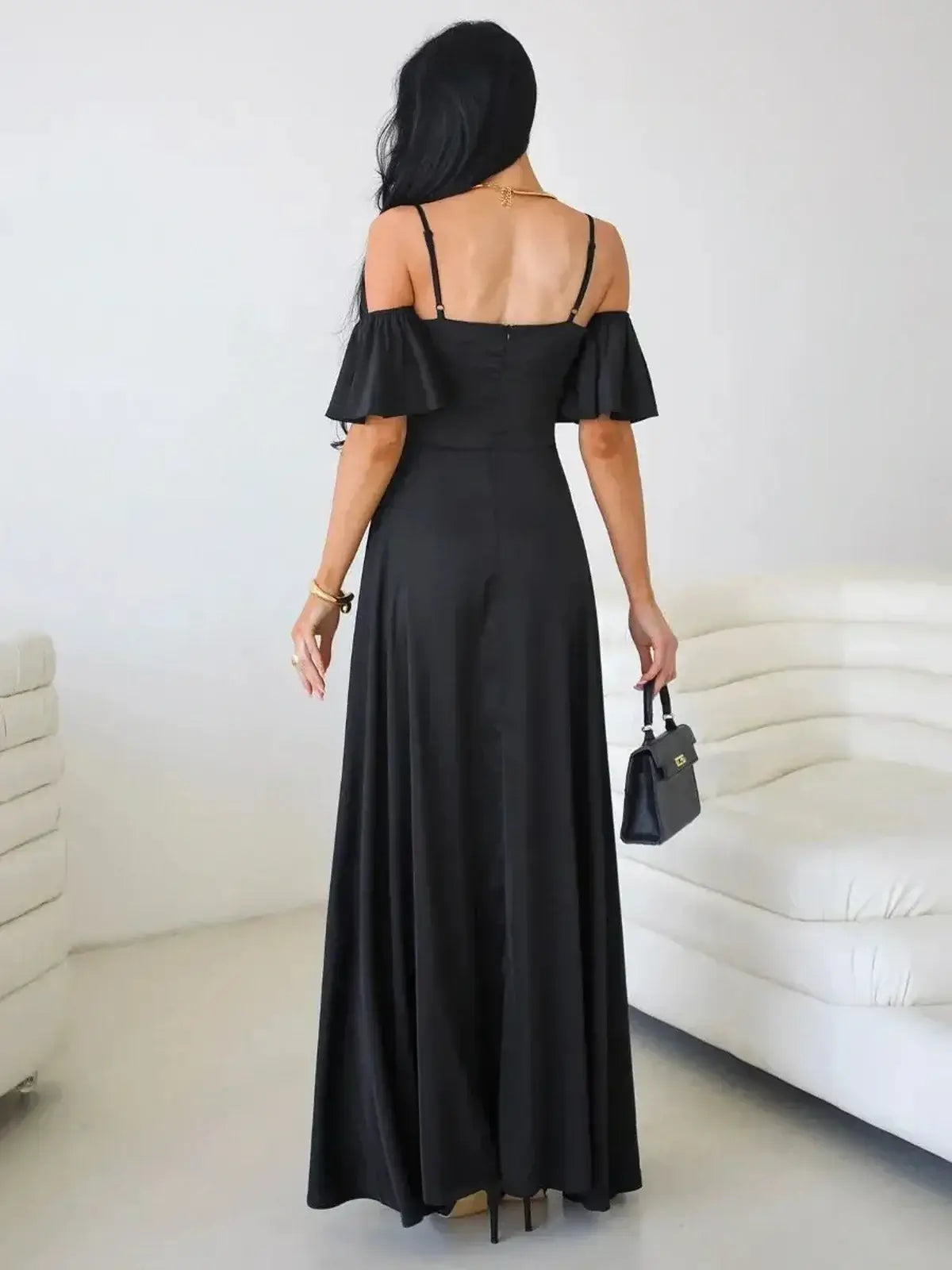 Back view of a black Maxi Dress Midnight Muse with off-shoulder flutter sleeves and a flowing silhouette.
